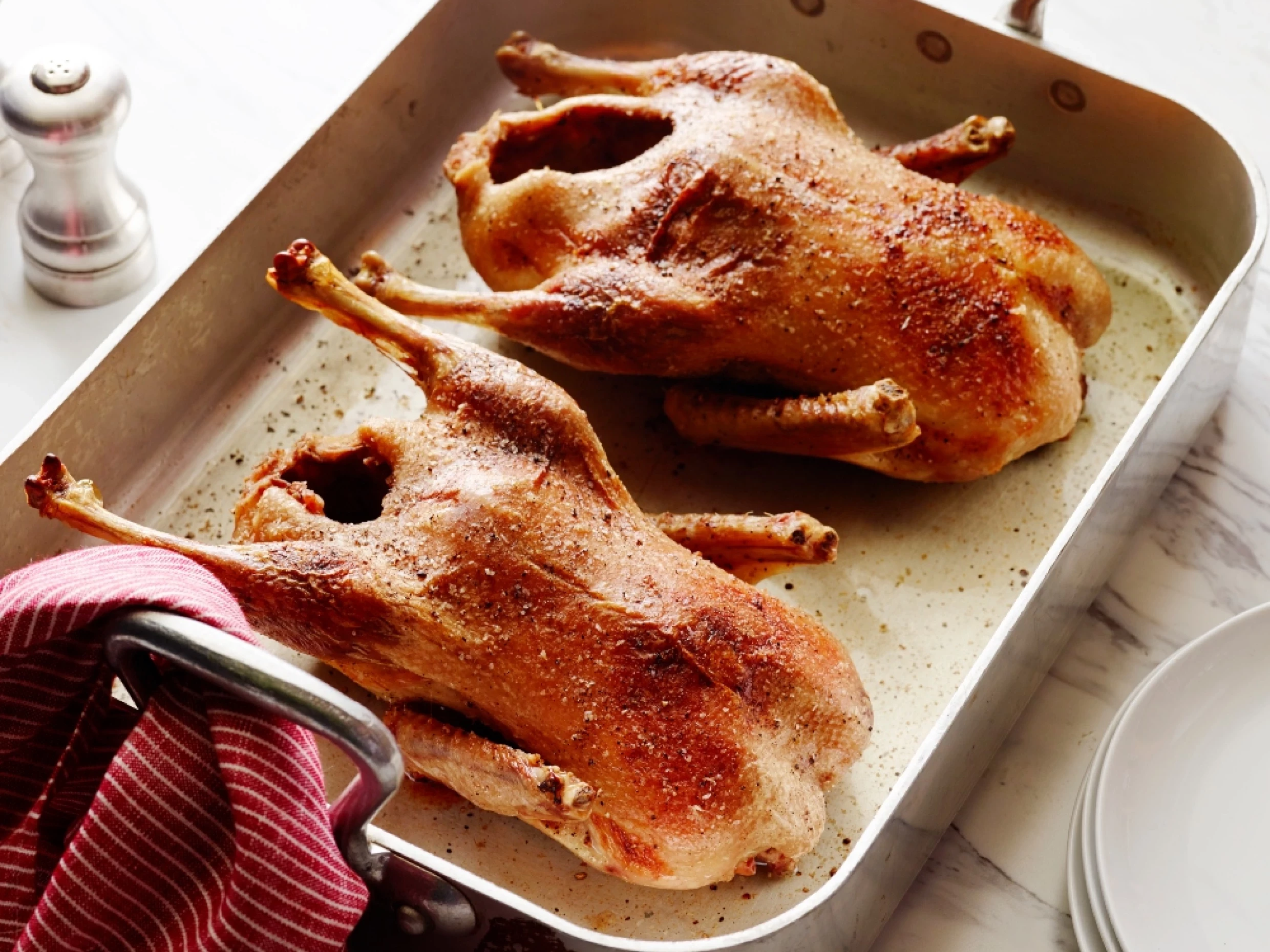 two roast ducks on a baking tray