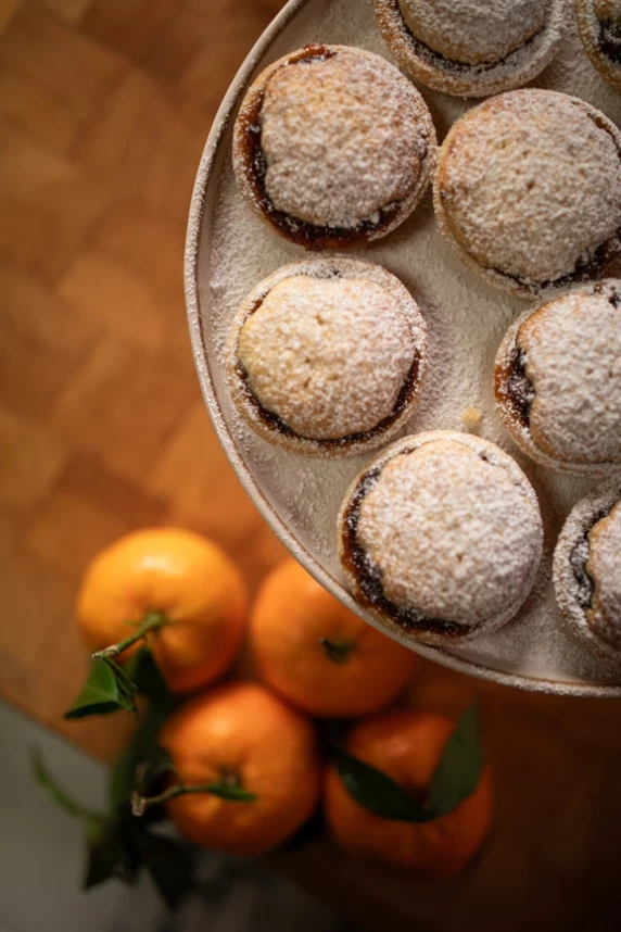 Plate of mince pies top shot top right corner with oranges in the backgroun