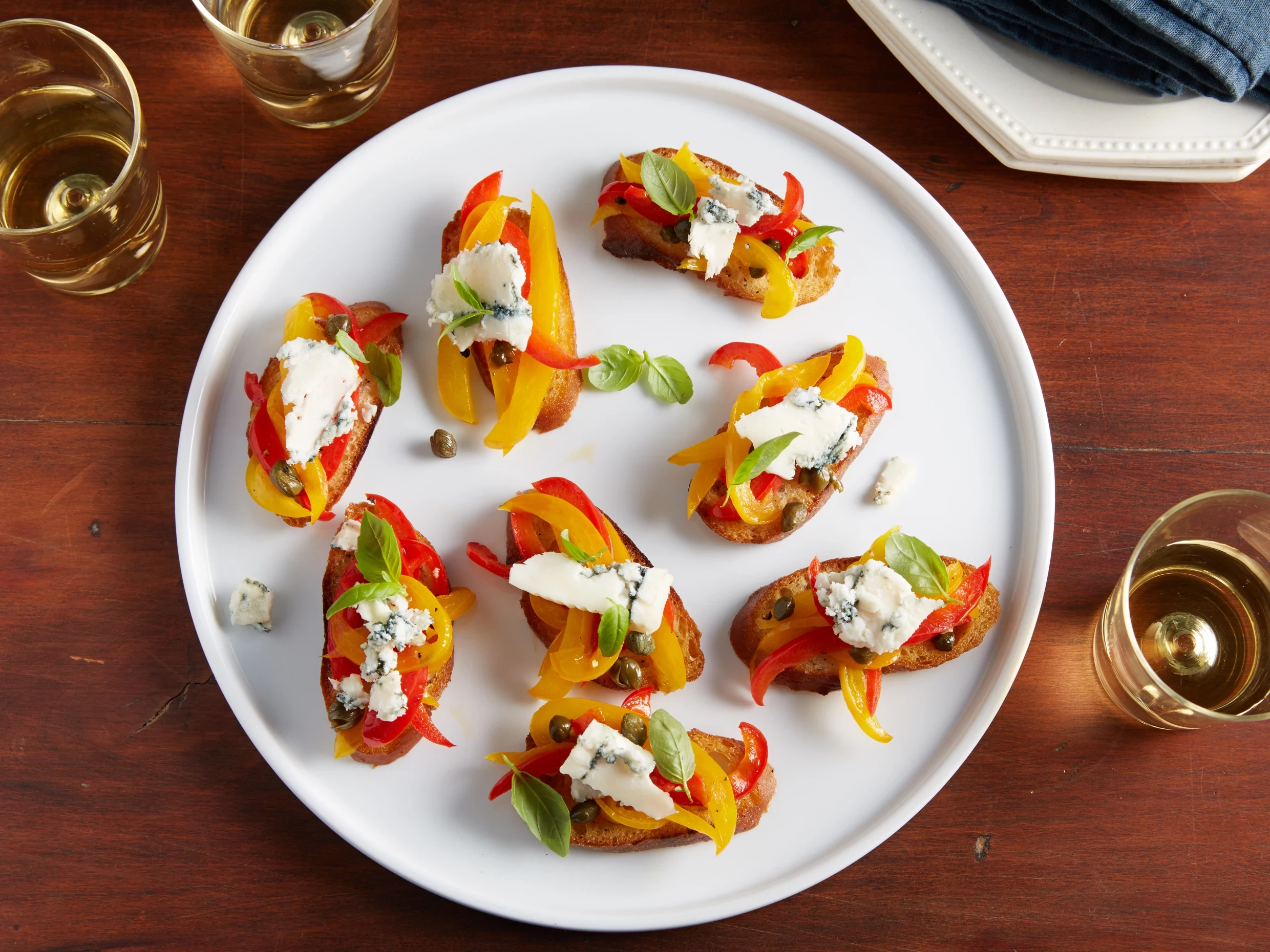 Grilled bruschetta with grilled red and yellow peppers, gorgonzola and basil oil